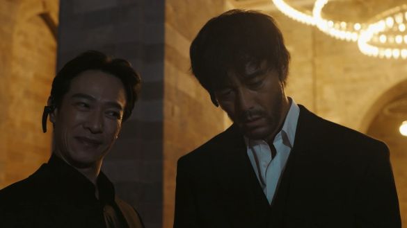 『VIVANT』第20話の野崎守。右の阿部寛さんは、襟元を開けた白いシャツに濃い色のジャケットとベストを着ている。左はリュウ役の堺雅人さん