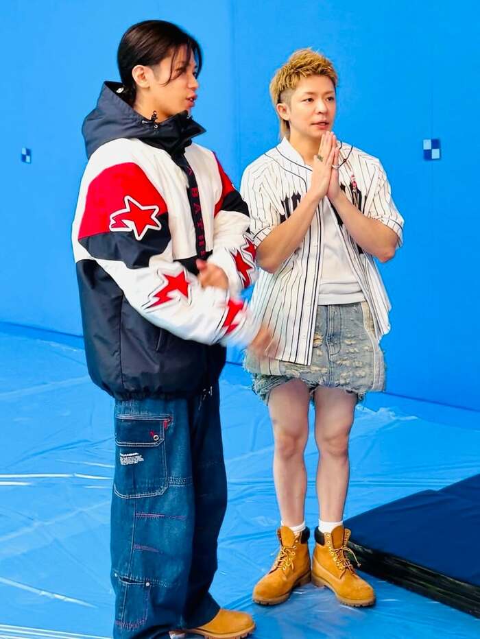 撮影の合間にデニムをまくり上げ、手を合わせる岸優太さんと隣の神宮寺勇太さん