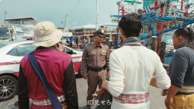VIVANT第十二話41:55、中央で後ろを向く乃木の白い身頃と腕まくりした袖。左右には野崎とドラムがいる