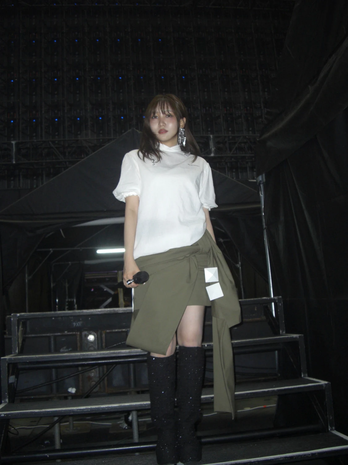 白いパフスリーブのブラウスとカーキのリボンスカートを着た幾田りらさん