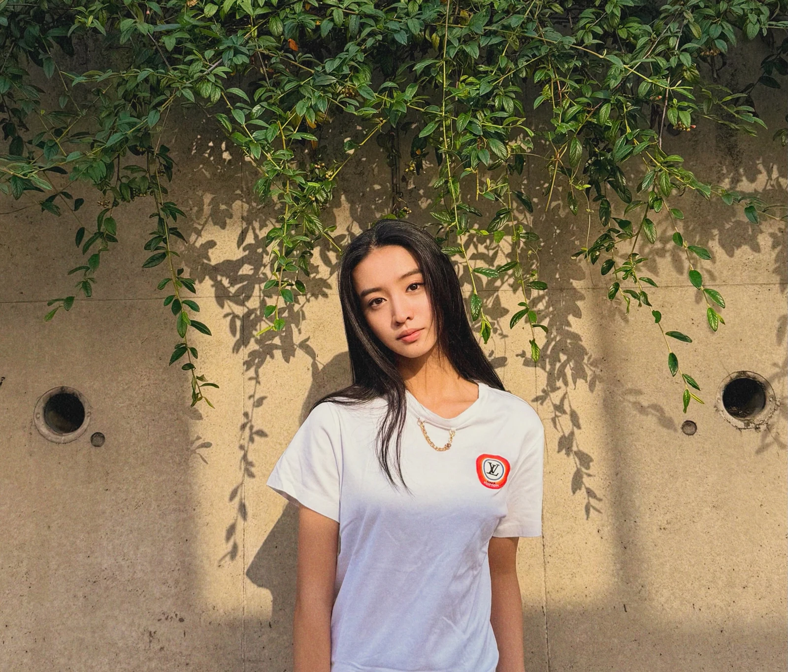 日なたの壁の前で白いLouis VuittonのTシャツを着るKōki,さん